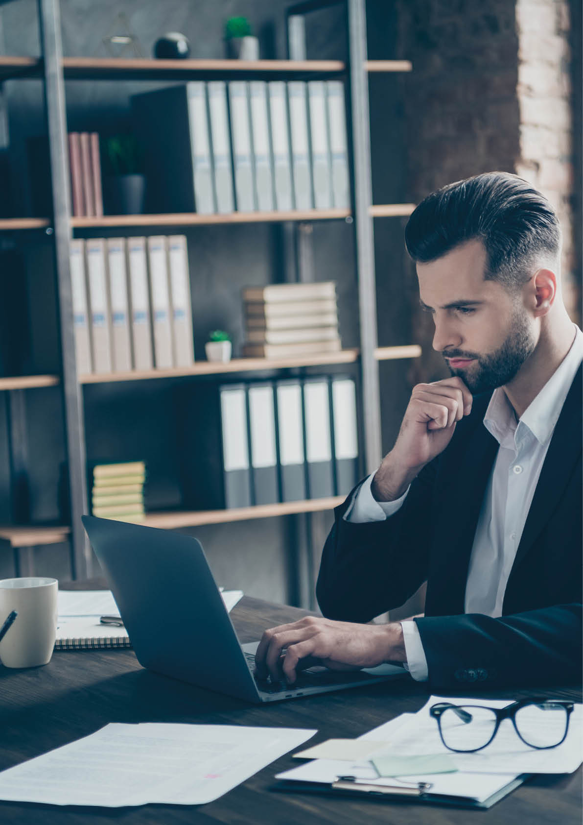 Profile photo of curious business brunet guy looking notebook table, reading colleagues email letters analyzing reports wear blazer shirt suit sitting chair office indoors
