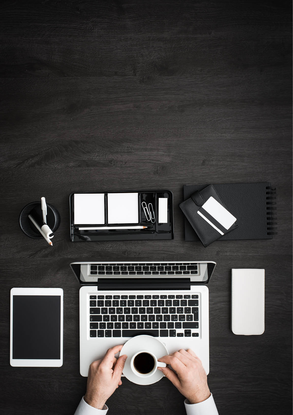 Businessman working at office desk and having a coffee break, he is holding a cup of espresso, business and lifestyle concept