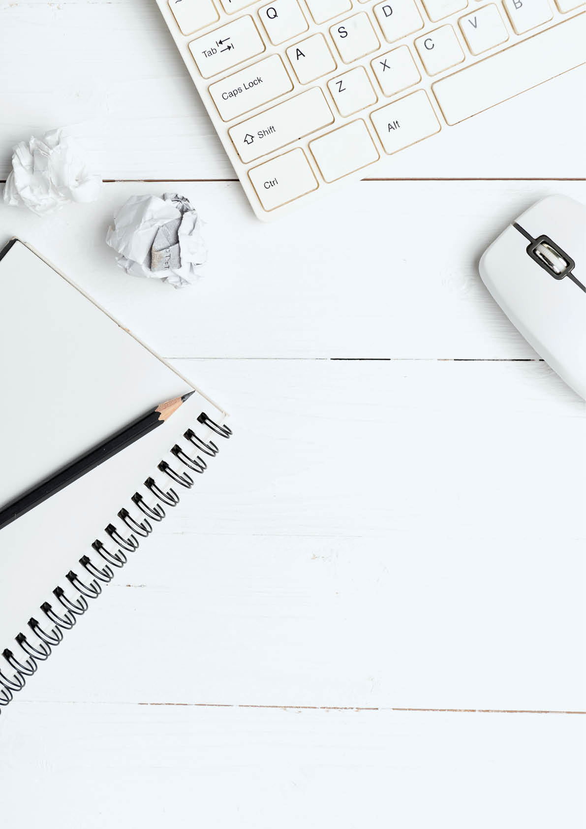 notepad and computer on white table background view from above