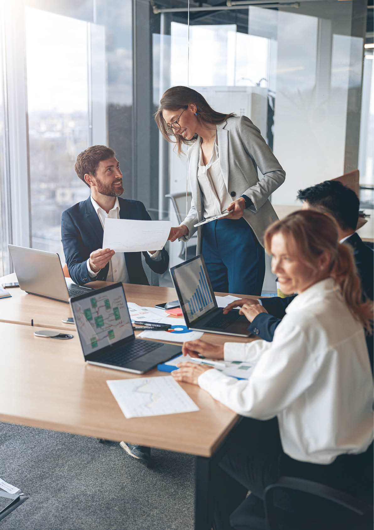 Beautiful business people are using gadgets, talking and smiling during the conference in office 
