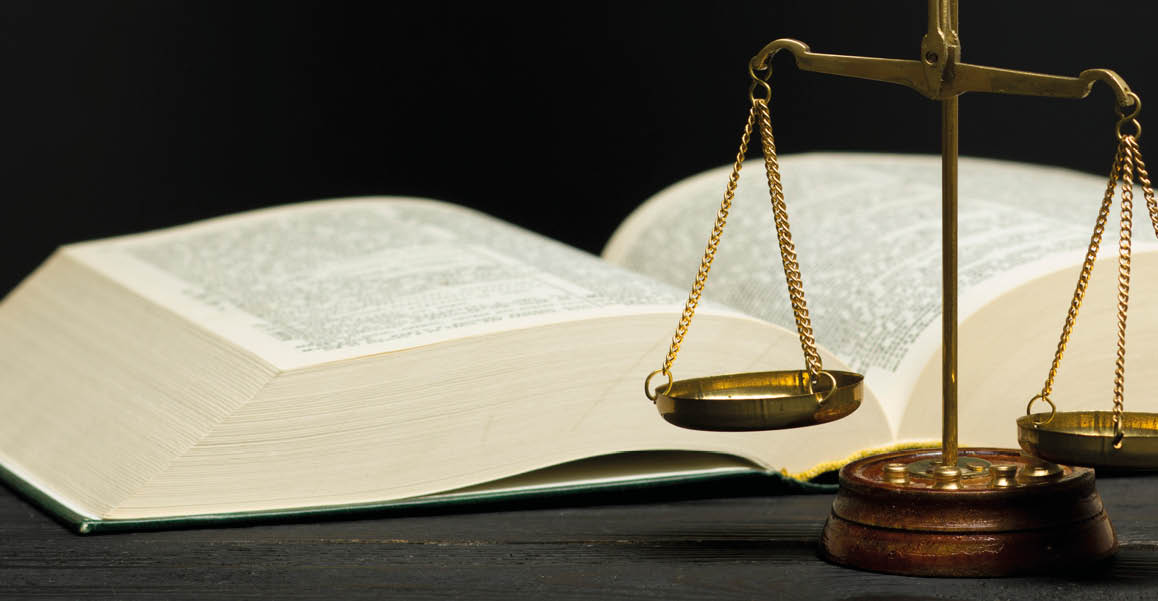 Law concept - Open law book with a wooden judges gavel on table in a courtroom or law enforcement office isolated on white background  Copy space for text 