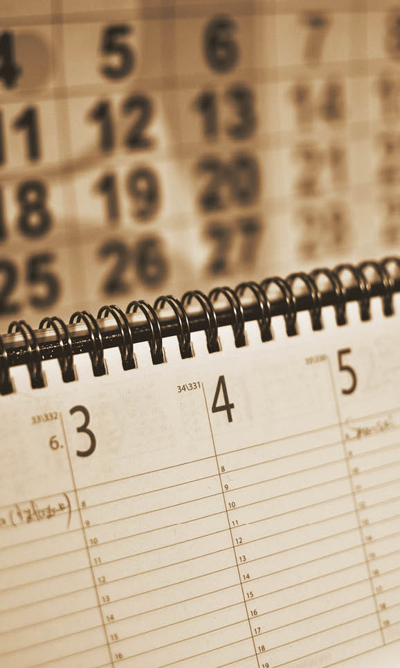 close up image of monthly table planner, calendar in background