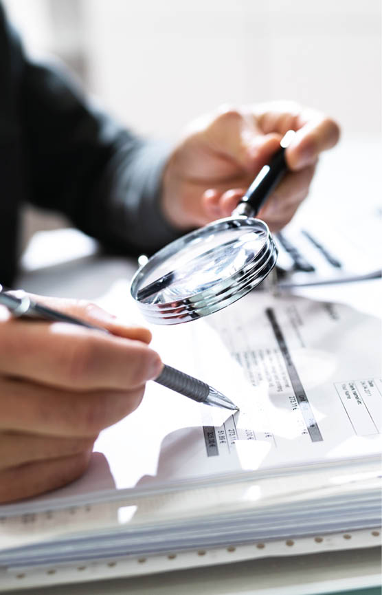 Audit And Fraud Investigation  Auditor Using Magnifying Glass On Document
