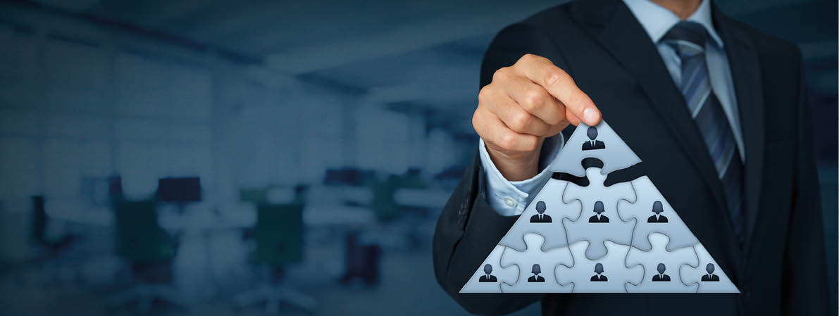 CEO, leadership and corporate hierarchy concept - recruiter complete team represented by puzzle in pyramid scheme by one leader person (CEO)  Wide banner composition with office in background  