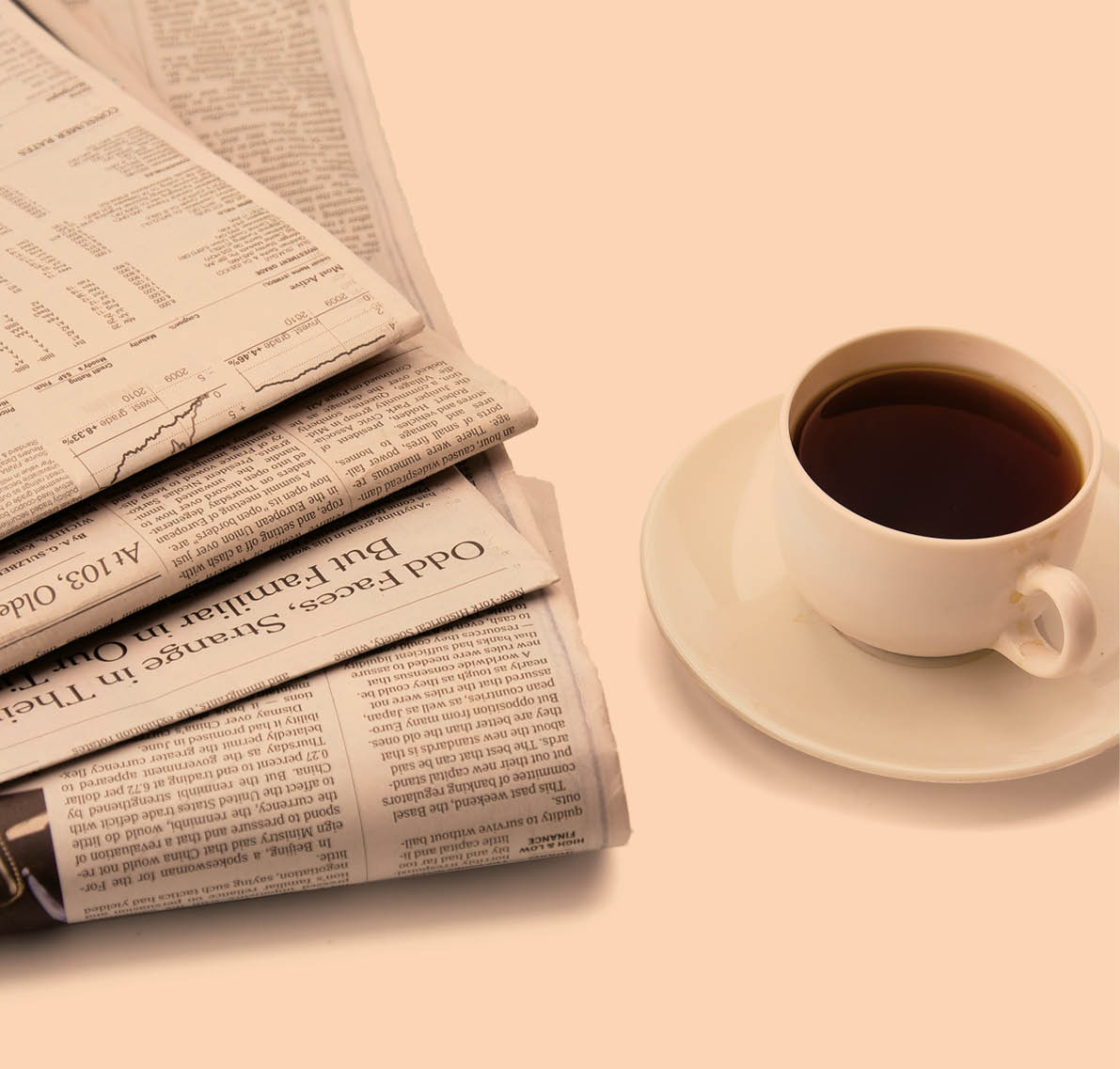 coffee cup near  newspaper