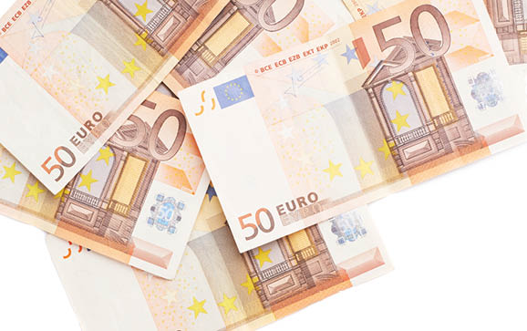 Surface covered with multiple fifty euro bank notes isolated over the white background