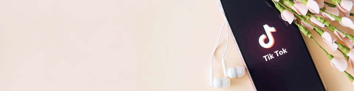 Tver, Russia-April 9, 2020, the tik tok logo on the smartphone screen on a beige background with headphones  Tick-Tok icon  logo of the current app  Tiktok social network  Space for text  Banner 