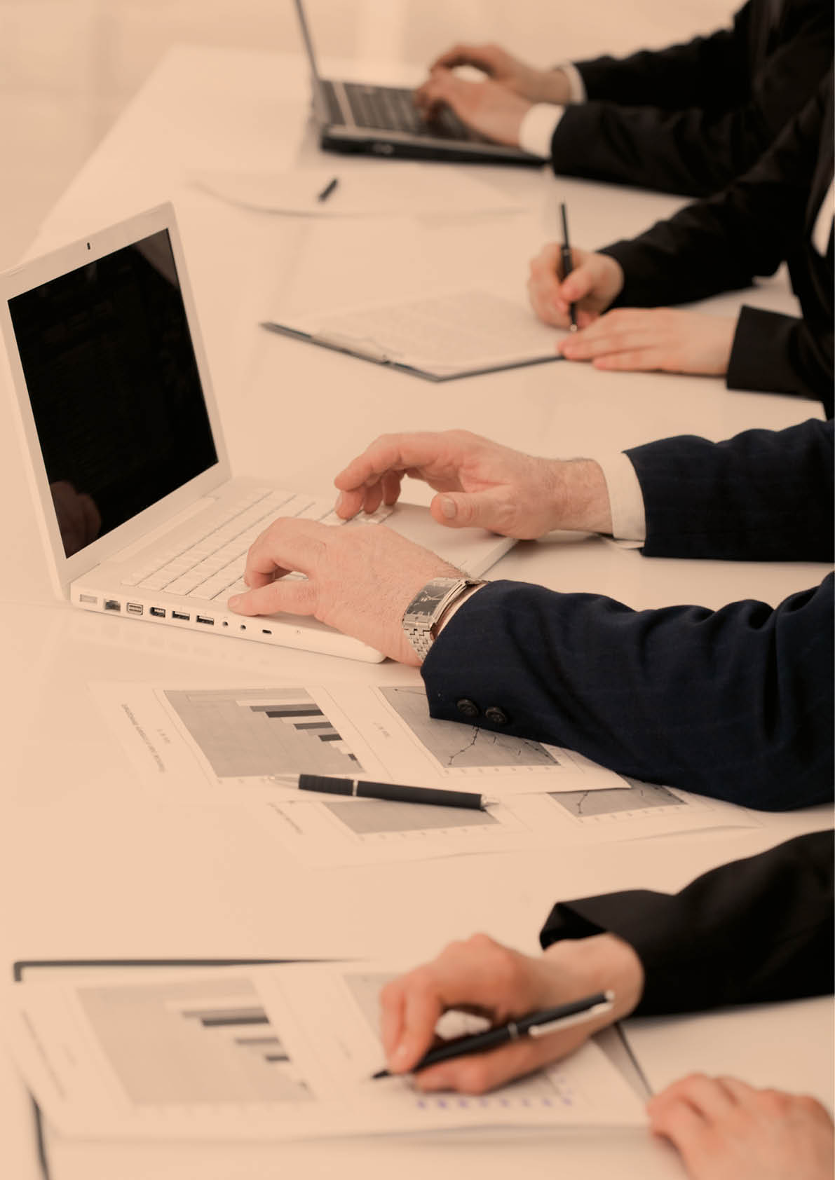 Image of row of people hands writing on papers and typing at briefing