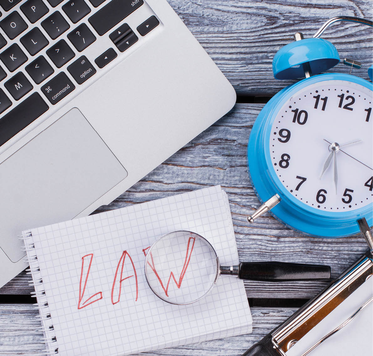 Law and time concept  Laptop with clipboard and gavel on white wooden table 