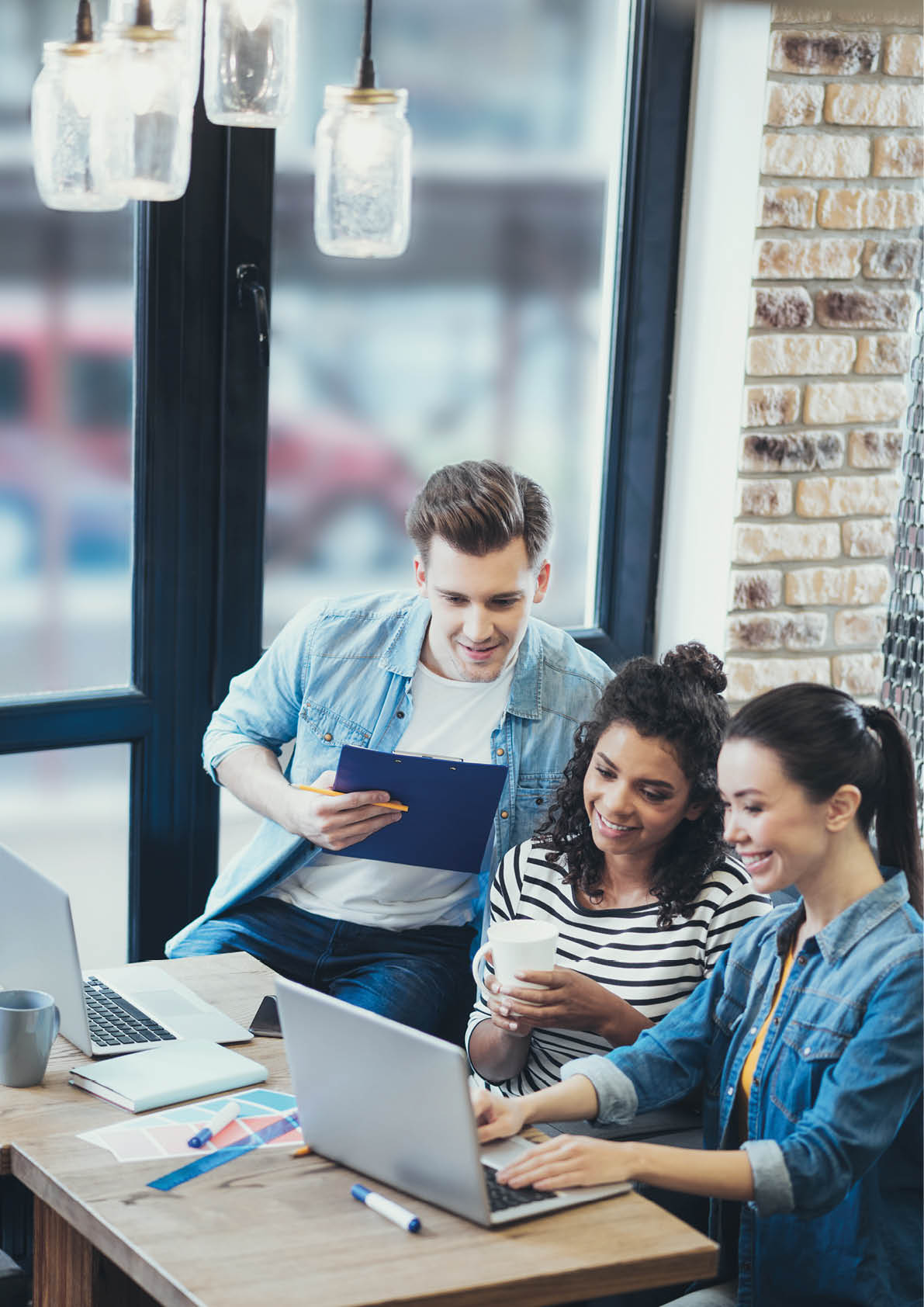 Share your opinion  Top view of energetic three colleagues working at cafe while preparing business plan