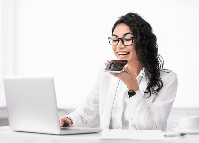 Voice Search  Mexican manager using personal mobile assistant app and working on laptop  Copy space