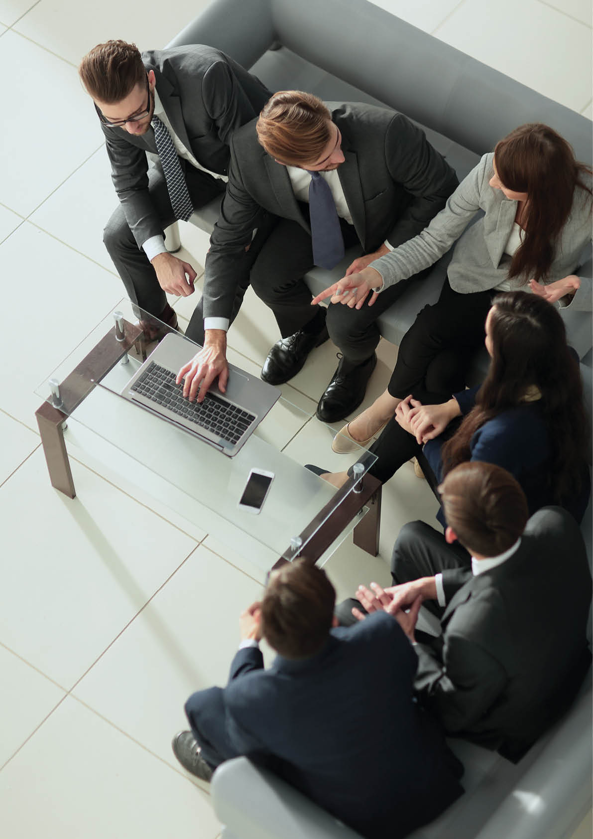 Cheerful young business people giving high-five while their colleagues looking at them and smiling 
