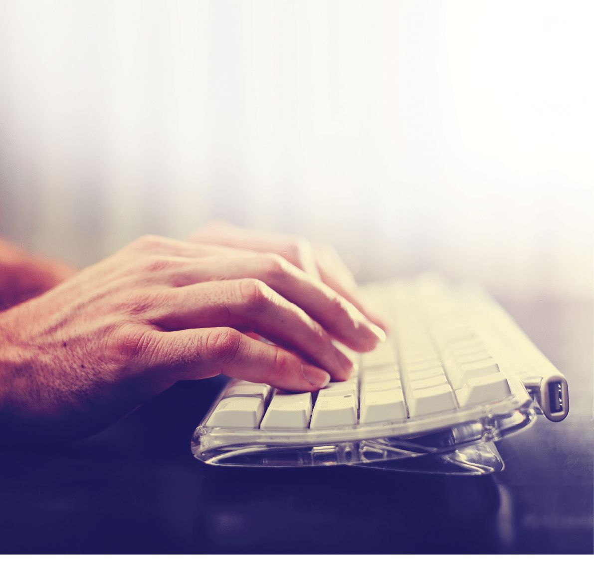 hands typing on laptop keyboard toned with a retro vintage instagram filter