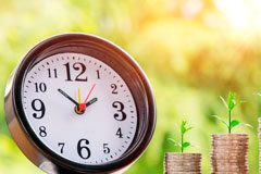 Prórroga a las empresas en la batalla frente al Covid-19 Reloj y dos montones de monedas de euro