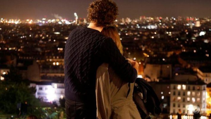 Una pareja se abraza mientras disfruta de la vista desde Montmartre pocos minutos antes del toque de queda nocturno debido a las restricciones contra la propagación de la enfermedad coronavirus (COVID-19) en París, Francia. 22 de octubre de 2020. REUTERS/Charles Platiau