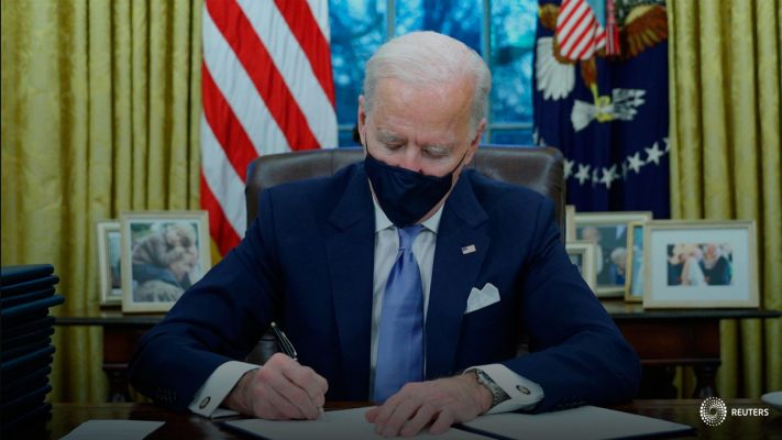El presidente de los Estados Unidos Joe Biden firma órdenes ejecutivas en el Despacho Oval de la Casa Blanca en Washington, después de su toma de posesión como el 46o Presidente de los Estados Unidos, Estados Unidos, el 20 de enero de 2021. REUTERS/Tom Brenner