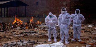 India registra aumento diario récord de muertes por coronavirus Hombres con trajes protectores están junto al cuerpo de su pariente, que murió de la enfermedad coronavirus (COVID-19), antes de su cremación en un campo crematorio en Nueva Delhi, India, el 4 de mayo de 2021. REUTERS/Siddiqui danés
