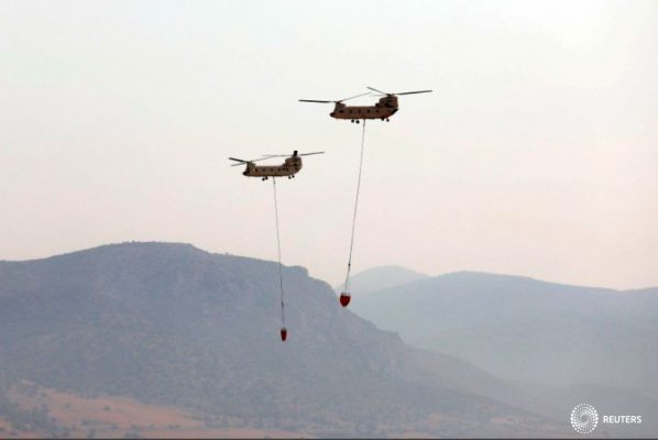 Dos helicópteros chinook egipcios sobrevuelen la base aérea militar de Elefsina, proporcionando asistencia para la lucha contra incendios en Grecia, 11 de agosto de 2021. REUTERS/Louiza Vradi