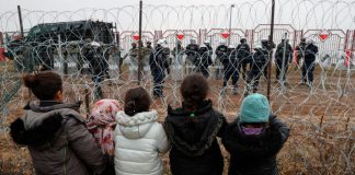 La UE enviará ayuda a los migrantes en la frontera con Bielorrusia Los niños se paran frente a una valla y se dirigen a los agentes de la ley polacos, que se encuentran al otro lado de la frontera, en la frontera bielorruso-polaca en la región de Grodno, Bielorrusia, el 17 de noviembre de 2021. Maxim Guchek/BelTA/Handout vía REUTERS