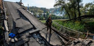 Ucrania y Rusia: Lo que necesita saber en este momento Un miembro del servicio de la Guardia Nacional de Ucrania camina sobre un puente sobre el río Siverskyi Donets destruido durante el ataque de Rusia a Ucrania, en la ciudad de Sviatohirsk, región de Donetsk, Ucrania, el 1 de octubre de 2022. REUTERS/Vladyslav Musiienko