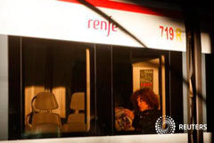 Diez años después, España recuerda a las víctimas de sus peores atentados Una pasajera lee el periódico en un tren en la estación de Atocha, en Madrid, el 11 de marzo de 2014