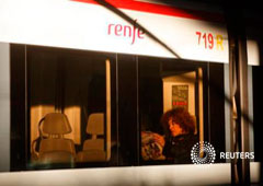 Una pasajera lee el periódico en un tren en la estación de Atocha, en Madrid, el 11 de marzo de 2014