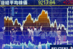 El Nikkei, al máximo nivel en 2 meses por el recorte de tipos Una pantalla de la bolsa y gente andando por la calle