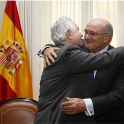 Carlos Carnicer y Carlos Dívar dándose un abrazo.