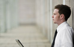 SEO para abogados (I): conceptos básicos Un abogado pensando mientras sostiente su portátil sentado en el suelo de la calle.