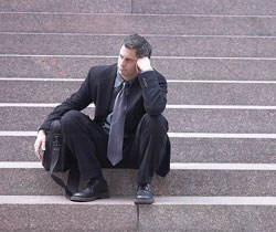 Un abogado sentado en unas escaleras pensando en su futuro.