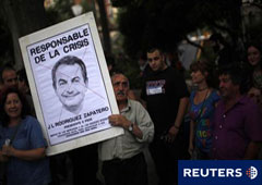 Un manifestante sujeta una pancarta con la cara del presidente del Gobierno, José Luis Rodríguez Zapatero, durnate una manifestación que pedía 