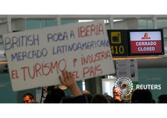 Un trabajador sostiene un cartel de protesta frente a un mostrador de facturación cerrado durante una huelga del personal de Iberia en la Terminal 1 de Barcelona, el 8 de marzo de 2013 Un trabajador sostiene un cartel de protesta frente a un mostrador de facturación cerrado durante una huelga del personal de Iberia en la Terminal 1 de Barcelona, el 8 de marzo de 2013