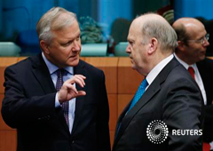 El comisario europeo de Asuntos Económicos y Monetarios, Olli Rehn talks, habla con el ministro de Finanzas irlandés, Michael Noonan (D), durante una reunión de ministros de Finanzas de la zona euro en Bruselsa, el 13 de mayo de 2013