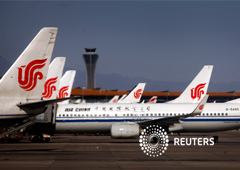 Un trabajador del aeropuerto inspecciona el transporte de menores de los aviones de Air China mientras están estacionados en el edificio de la terminal de internacional del aeropuerto de Beijing febrero 6, 2012. El gobierno chino dijo el lunes que ha proh