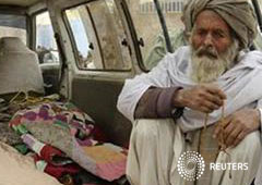 Un anciano afgano junto a los cadáveres de personas muertas en Kandahar