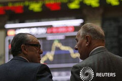 El Ibex baja por tomas de beneficios tras el acuerdo griego Dos agentes bursátiles el 16 de enero de 2012 en Madrid.