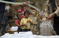 El agua contaminada mata a millones de niños cada año unos niños esperan recoger agua distribuida por el Gobierno local en el condado Luoping de Qujing, en la provincia de Yunnan el 22 de marzo de 2010.