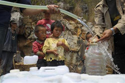 unos niños esperan recoger agua distribuida por el Gobierno local en el condado Luoping de Qujing, en la provincia de Yunnan el 22 de marzo de 2010.