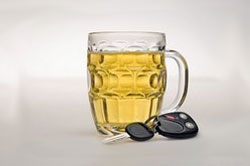 Una jarra de cerveza al lado de un juego de llaves de un coche