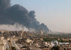 Una vista general con una columna de humo de una fábrica de cemento controlada por el Gobierno sirio, en Alepo, el 9 de agosto de 2016
