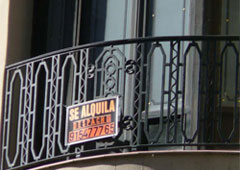 Un balcón con un cartel, en el cual pone que se alquila