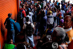 Colombia, Ecuador y Perú piden apoyo internacional ante ola de migración venezolana Un grupo de personas espera frente a una estación de metro cerrada después de un apagón en Caracas, Venezuela, 29 de agosto de 2018