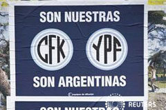 La expropiación de YPF avanza en Argentina pese a la presión un hombre habla por su móvil dentro de su coche junto a un letrero que reivindica la propiedad argentina de las empresas CFK - YPF, en Buenos Aires