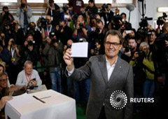 El presidente catalán, Artur Mas, muestra su papeleta tras participar en la consulta en Barcelona el 9 de noviembre de 2014