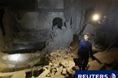 La OTAN ataca el complejo de Gadafi, según testigos Un oficial de policía mira el edificio destrozado del Alto Comisionado para la Infancia , el 10 de mayo de 2011 en Trípoli.