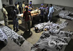 Rescatadores y soldados paramilitares junto a cadáveres tras el ataque contra el aeropuerto internacional Yinah de Karachi en una morgue de un hospital