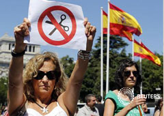 una funcionaria levanta un cartel contra los recortes mientras bloquean un calle durante una protesta contra las medidas de austeridad del Gobierno, en el centro de Madrid