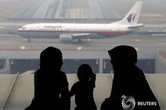 Malasia niega que el avión desaparecido volara durante horas Dos mujeres y una niña frente a un avión de Malaysia Airlines en el aeropuerto de Kuala Lumpur el 13 de marzo de 2014