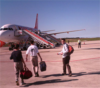 Unos pasajeros a punto de subirse a un avión.