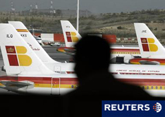 En la imagen, silueta de un pasajero ante varios aviones de Iberia en el aeropuerto de Barajas, en Madrid, el 13 de noviembre de 2010.